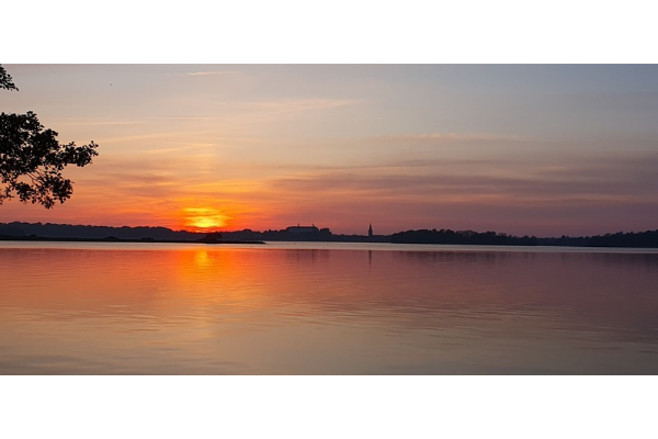 Orangefarbener Sonnenuntergang über dem Grossen Plöner See